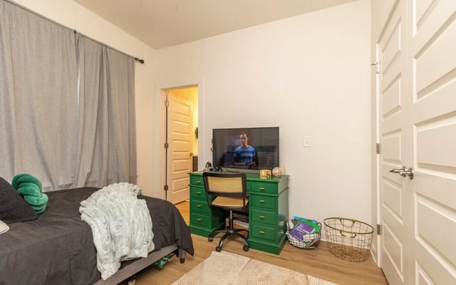 Bed green desk television chair basket bedroom at Varsity Club in Clemson Student Accommodation